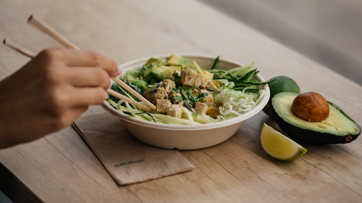 Delicious tofu salad with avocado and zucchini noodles on wooden table. Perfect for health-conscious food lovers.